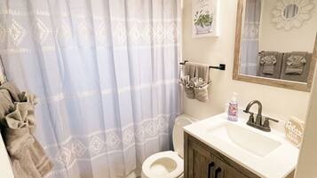 Kombinasi shower/bathtub, pengering rambut, handuk, dan tisu toilet