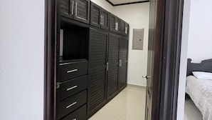 Ein Schlafzimmer mit einem Bett, einem Kleiderschrank und einer Tür zu einem anderen Raum.
