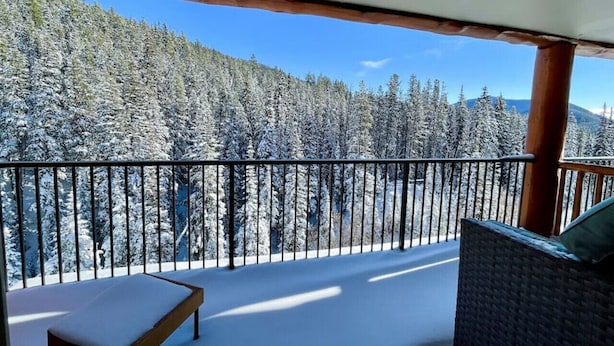 A balcony with a view of snow-covered trees and a clear sky. - Apex Mountain ~ Mountain Tranquility (Hedley)