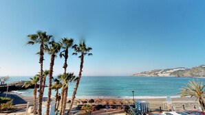 A beach with palm trees, a clear sky, and a view of the sea. - NEW APARTAMENT WITH LARGE TERRACE JUST ON THE BEACH W/ FAST  INTERNET (Almuñécar)