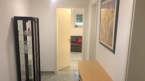 A hallway with a wooden desk, a glass cabinet, and a framed picture on the wall. - Room in the countryside near Cologne/Bonn Airport (Roesrath)