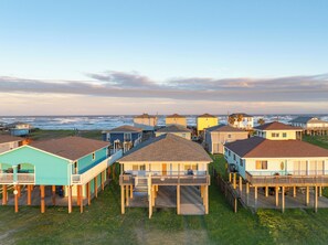 Un quartier résidentiel situé sur la côte, où les maisons sont construites sur pilotis, et qui offre des balcons et une vue directe sur l’océan.