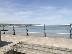 A pier with a metal railing overlooking a calm body of water. - Bluebell Apartment (Swanage)