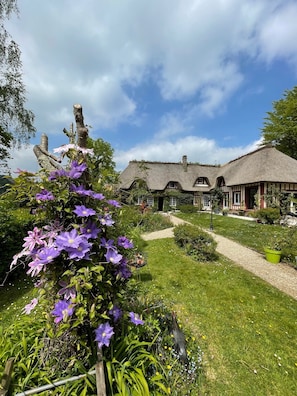 A traditional thatched-roof house with a garden path leading to it. - la Fontaine Romy (Genneville)