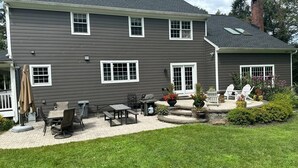 A two-story house with a patio area featuring outdoor furniture and a grill. - Large Home w/ Private Pool, Gym, Sauna, 7 Bedrooms, Sleeps 21 (Severn)
