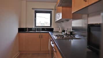 Molineux Apartment | Private kitchen | Microwave, electric kettle, toaster, cookware/dishes/utensils