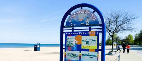 Un panneau indicateur sur la plage, sur lequel on peut lire « Ludington » et « Stearns Park Beach ».