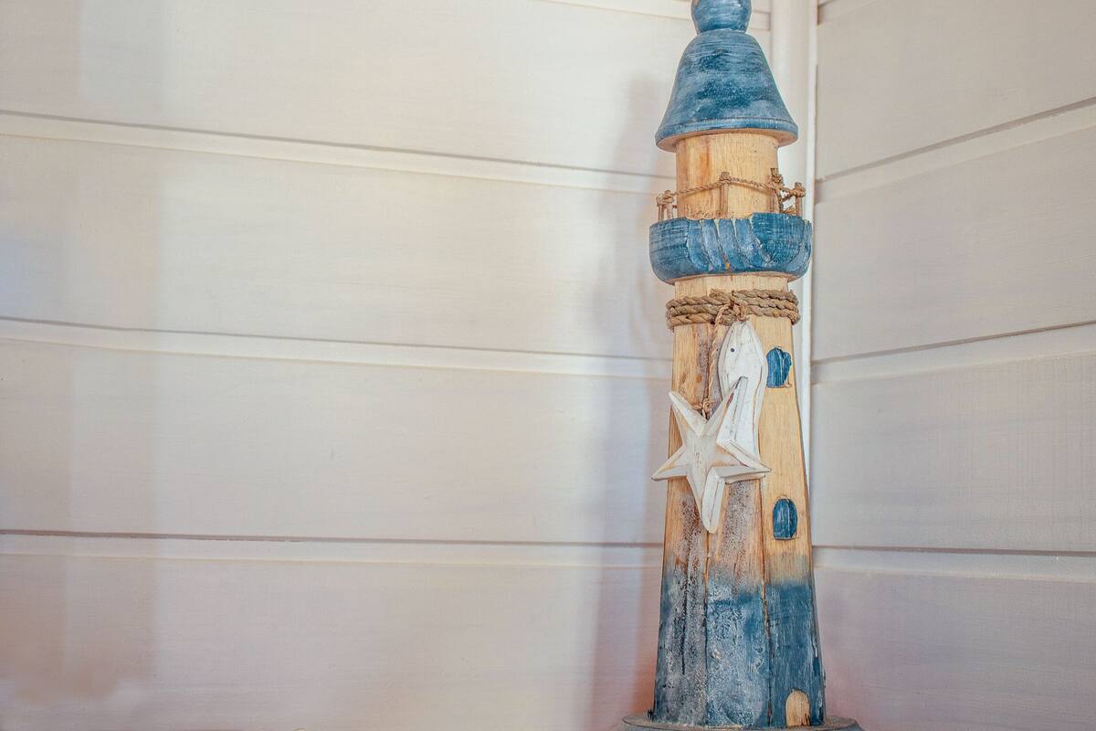 A lighthouse model with a rope and starfish decoration.