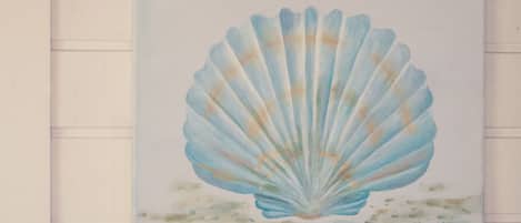 A framed artwork of a seashell on a wall.