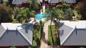 A residential area with two houses, a swimming pool, and surrounding greenery. - Bon Amour Punta del Diablo (Punta del Diablo)