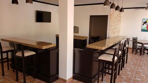 Una cocina con encimera de granito, armarios oscuros y salpicadero de azulejos.