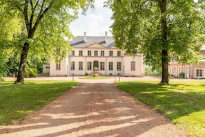 A building with a symmetrical facade, a central entrance, and a gravel pathway leading to it. - Chambres D'hôtes Vichy : Château de Charmeil (Charmeil)