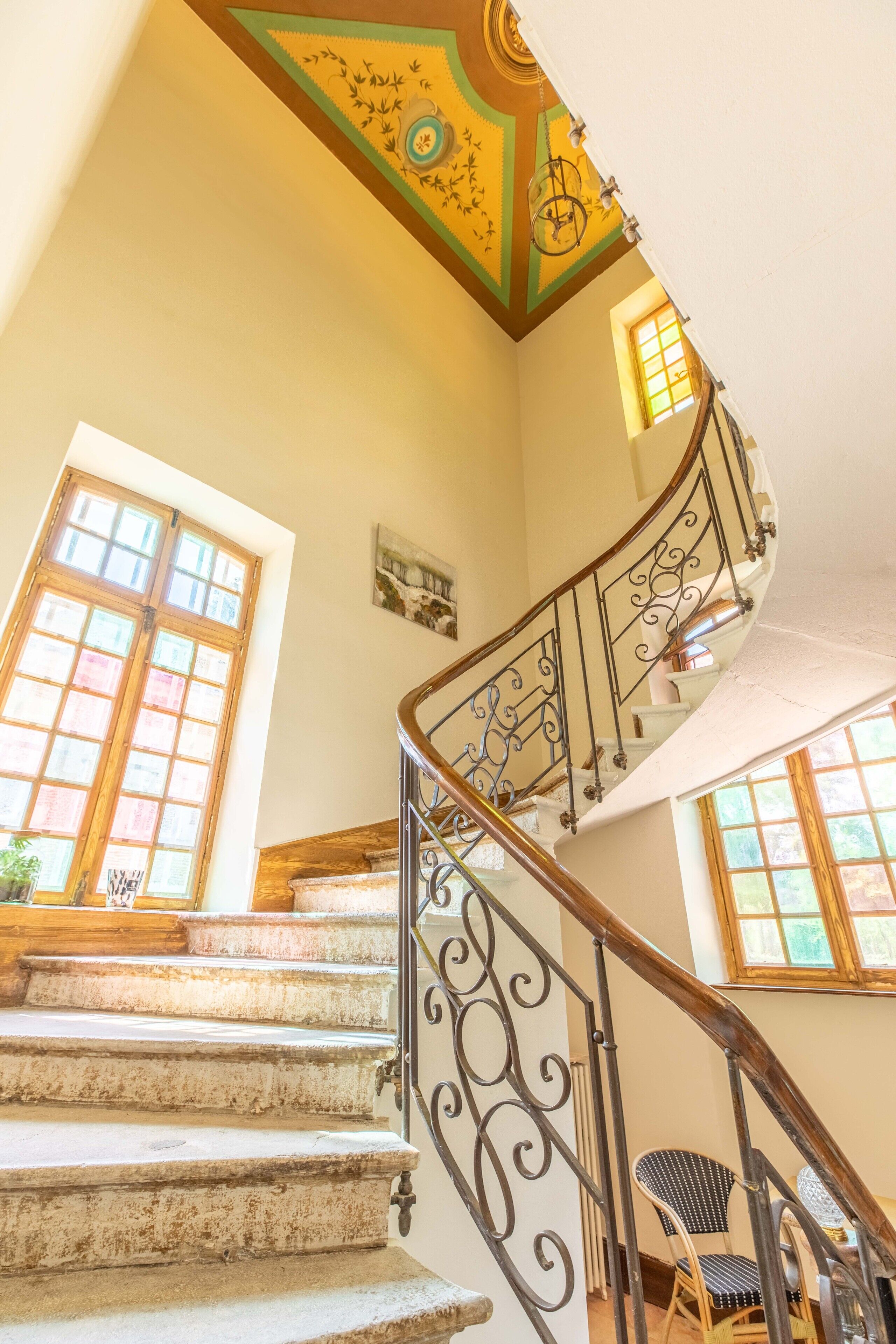 A staircase with ornate metal railings and a decorative ceiling.