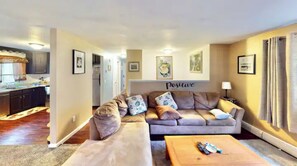 Relax in this stylish living room with a sofa, coffee table, and mounted TV.