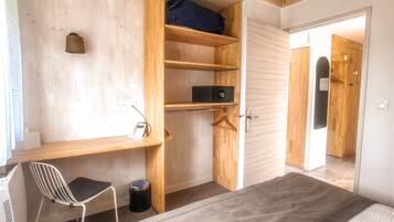 A bedroom with a bed, a desk, and a wardrobe.