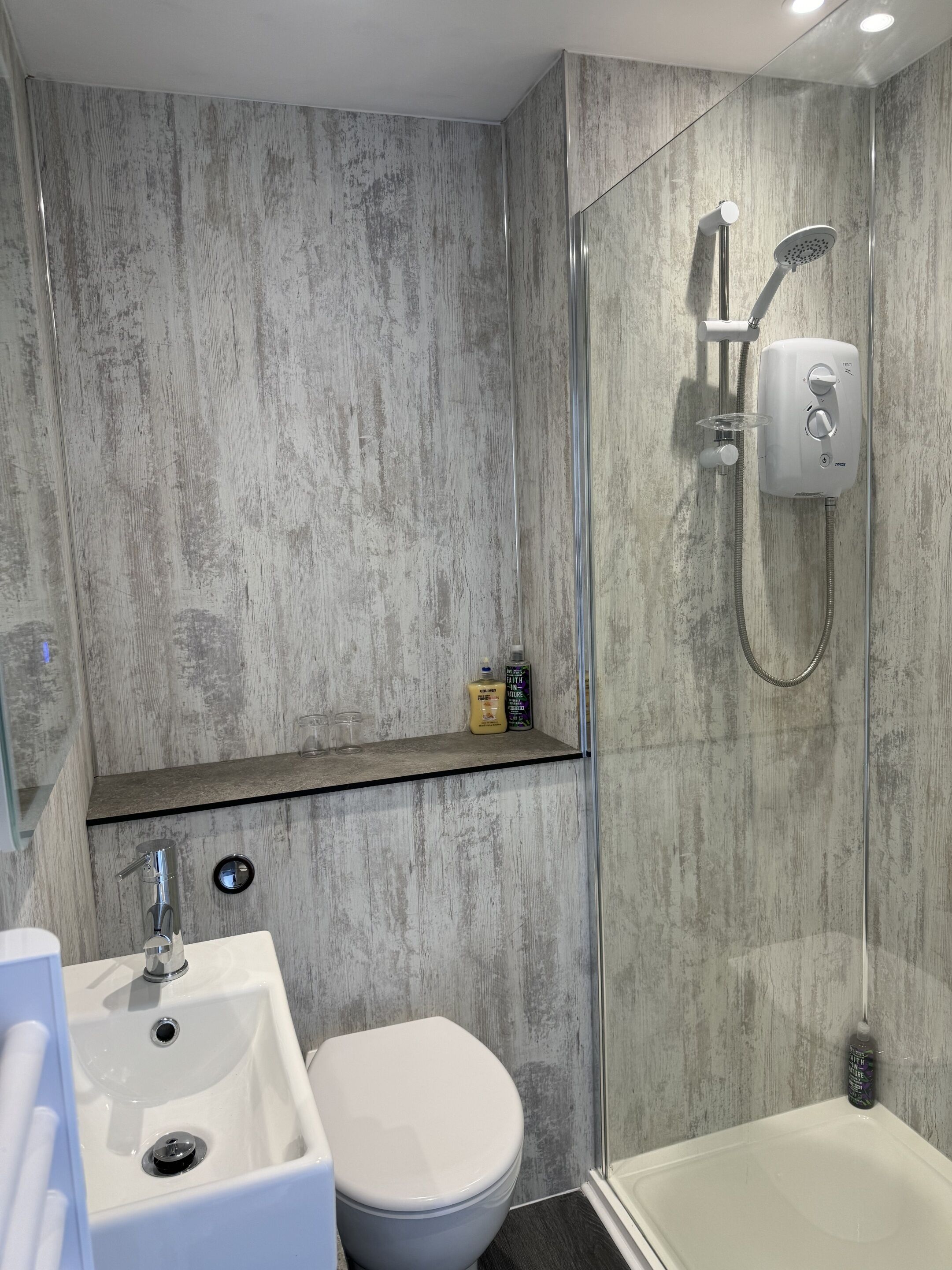 Ein modernes Badezimmer mit Dusche, Toilette und Waschbecken.