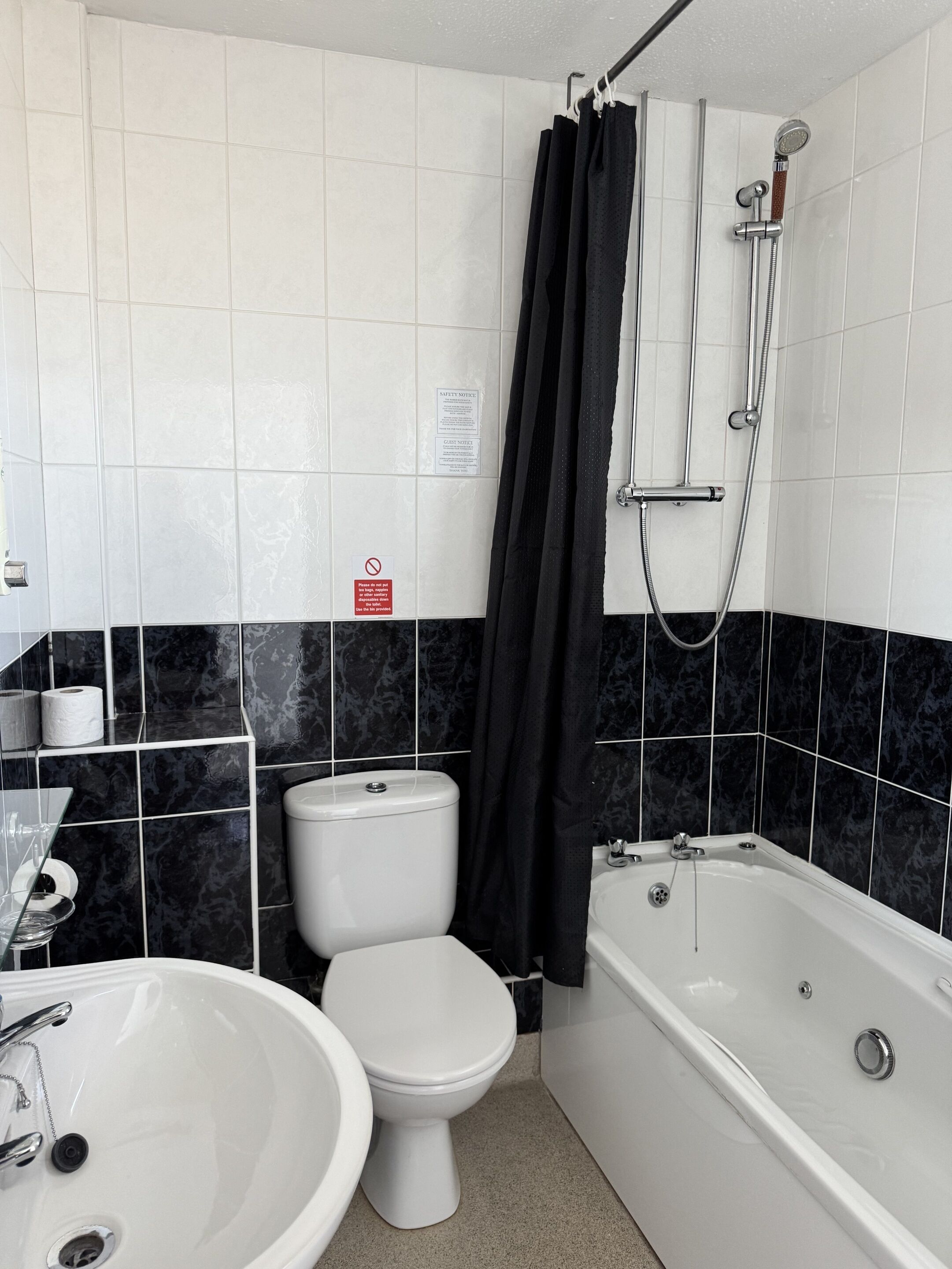 Une salle de bain avec des toilettes, un lavabo et une baignoire.
