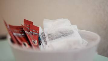 A bowl containing tea bags and a white cup.