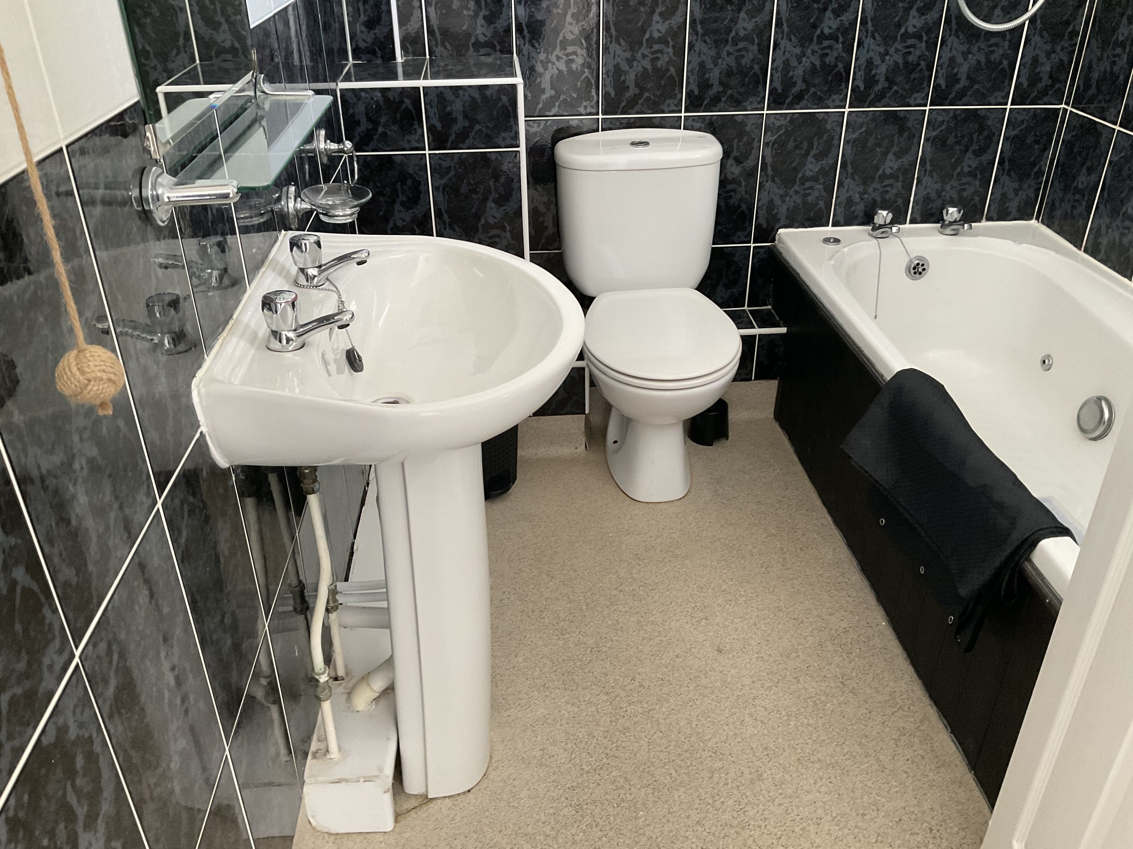 Een moderne badkamer met een wit wastafelmeubel, toilet en bad.