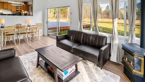 A modern living room with a leather sofa, a wooden coffee table, and a fireplace. - Rainier Estates' 5 Acre, 3100sqft, HotTub, Events (Elbe)