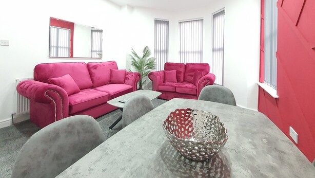 A room with two pink sofas, a grey table, and a decorative metal bowl. - Dysa Banks Apartments (Blackpool)
