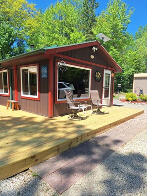 A small cabin with a porch, outdoor seating, and a sign indicating it's a cabin. - Cabin tucked into the woods! Trail access for ATV/UTV & snowmobiles.
(Pembine)
