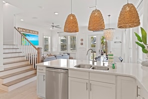 Enjoy meals in the spacious kitchen with a central island, sink, and dishwasher, and dine in the adjacent area with a bench and table.