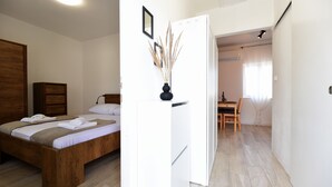 Una camera da letto con un letto di legno, un armadio bianco e un piccolo tavolo con una sedia.