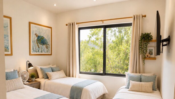 A bedroom with two beds, a large window, a fan, and a TV.