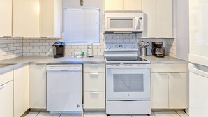 A modern kitchen with white cabinets, a built-in microwave, a dishwasher, and an oven. - Stylish 2BD/2BA Beach Villa at Hilton Head Resort (Hilton Head Island)