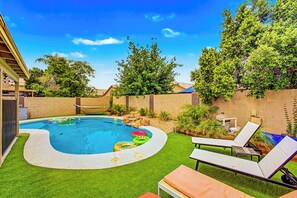 A backyard with a swimming pool, inflatable rings, and lounge chairs. - View Fireworks, Restaurants, Stadiums, Heated Pool (Peoria)