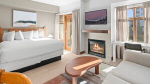 A modern hotel room with a large bed, a fireplace, a sofa, and a TV mounted on the wall. - Sundial C102 | Ski-in/Ski-out | Mountain Views | Pools & Hot Tubs | Ski Valet (Park City)