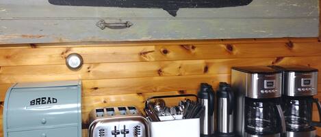 Una encimera de cocina con un tostador antiguo, una panificadora y una cafetera.
