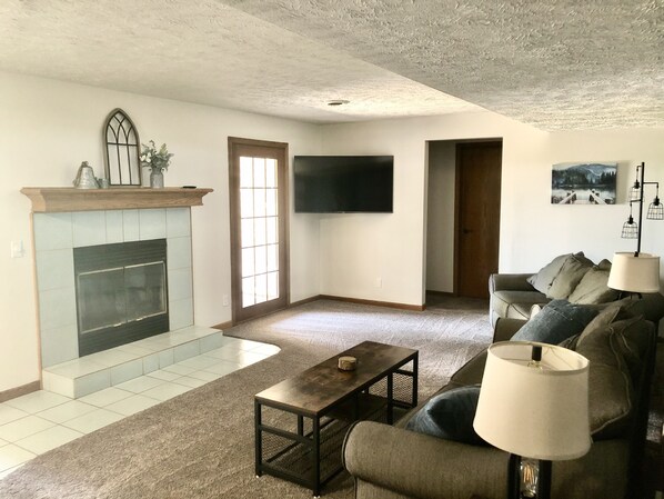 A living room with a fireplace, a flat-screen TV, a sofa, and a coffee table.