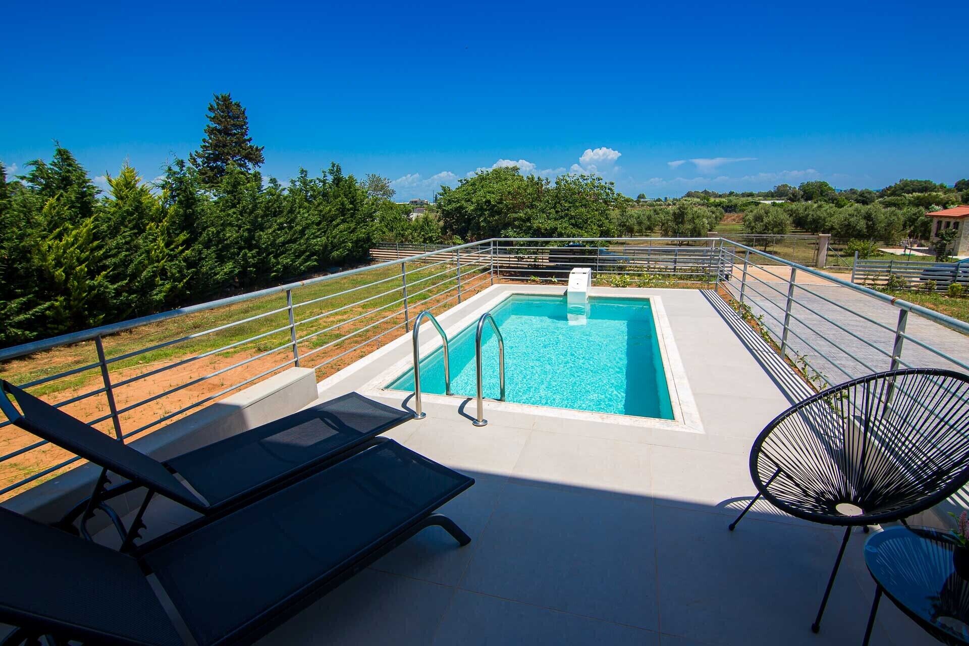 A rooftop pool with a clear view of the surrounding landscape, including trees and distant buildings.