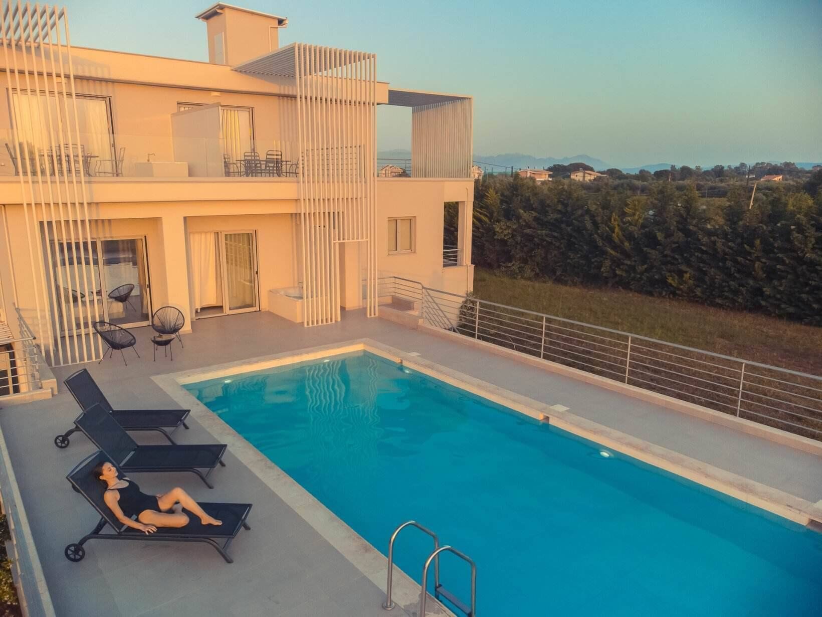 Un edificio moderno de dos pisos con zona de piscina en la azotea.
