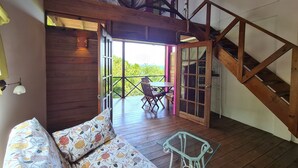 Un intérieur en bois avec un canapé, une table en verre et un escalier.