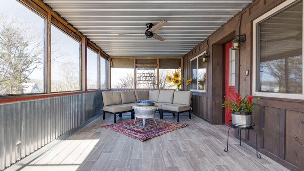 A covered porch with a ceiling fan, two sofas, a coffee table, and a rug. - Spacious 4BR/4BA Table Rock Lake Retreat (lampe)