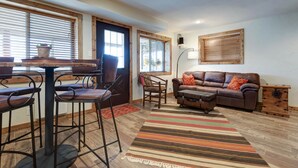 A cozy living room with a brown leather sofa, a wooden coffee table, and a striped rug. - Spacious 4BR/4BA Table Rock Lake Retreat (lampe)