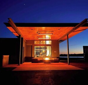 Un edificio moderno con un amplio acceso de vidrio y una terraza de madera.