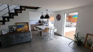 Uma cozinha moderna com área de refeições, uma escadaria e vista para o exterior.