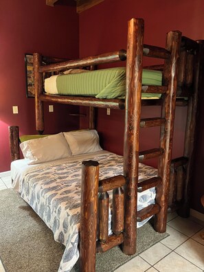A bunk bed with a wooden frame and patterned bedding. - Log Cabin/Cottage on Watts Bar Lake (Ten Mile)