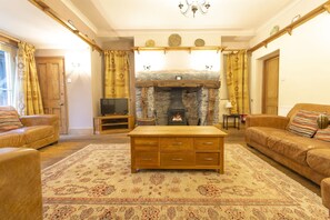 Cozy living room with a fireplace, television, and comfortable sofas.