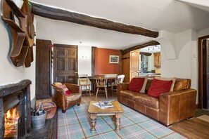 Cozy living room with a fireplace, comfortable seating area, and a functional kitchen space.