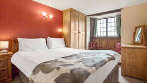 Un dormitorio con una cama grande, un armario de madera y una ventana con cortinas.