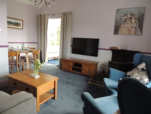Relax in a comfortable seating area with a sofa and armchairs, a coffee table, and dining table for four.