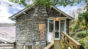 A stone building with a wooden deck leading to a glass door. - Lake District cottage with gorgeous views in Beatrix Potter country (Ambleside)