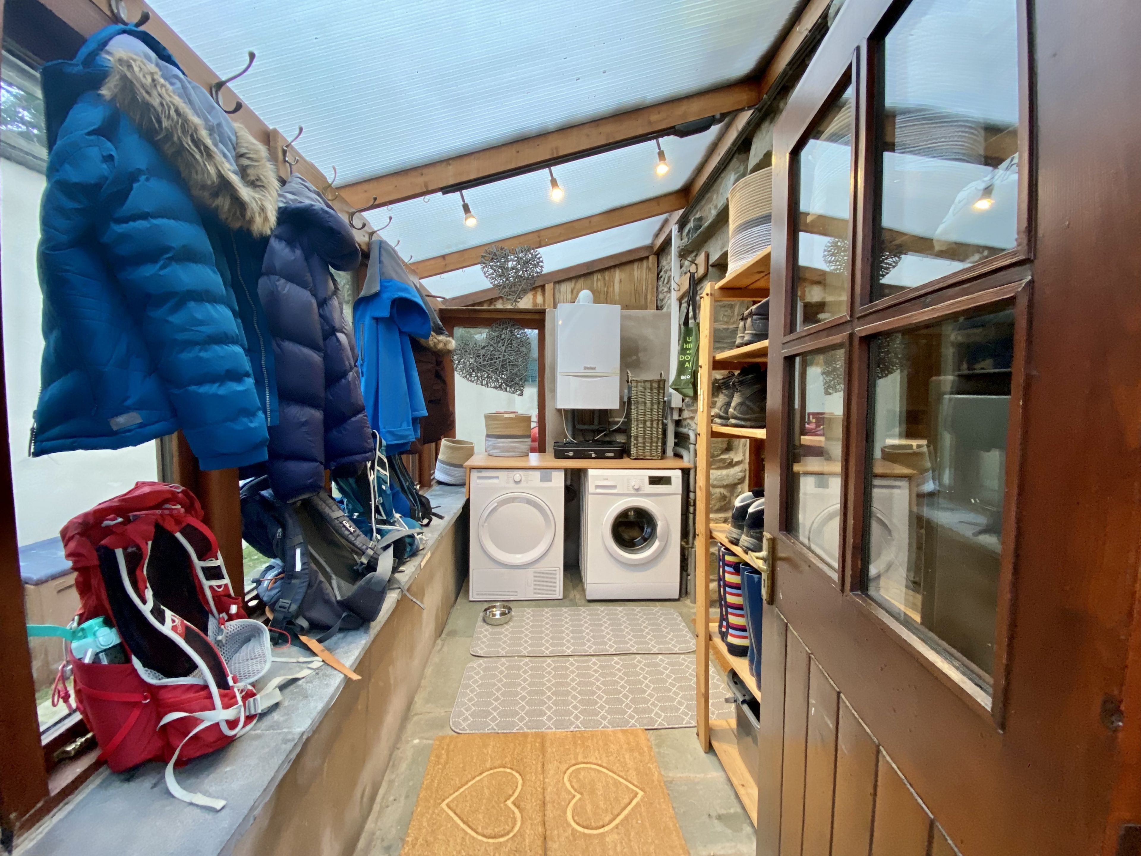Une petite buanderie équipée d’un lave-linge, d’un sèche-linge et d’un étendoir.