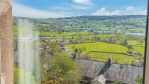 Ländliche Landschaft mit einem Dorf, grünen Feldern und einem See.