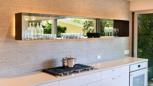 Una cocina moderna con un espejo grande, una estufa a gas y una encimera con cristalería.